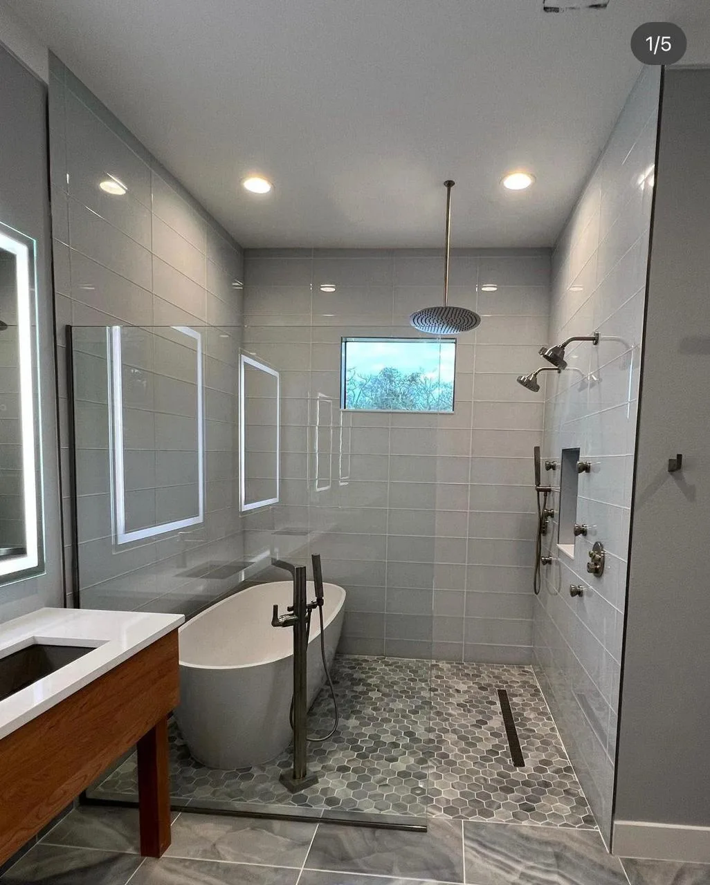 Remodeled bathroom with glass shower enclosure and patterned tile floor